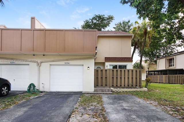 multi unit property featuring a garage and a front lawn