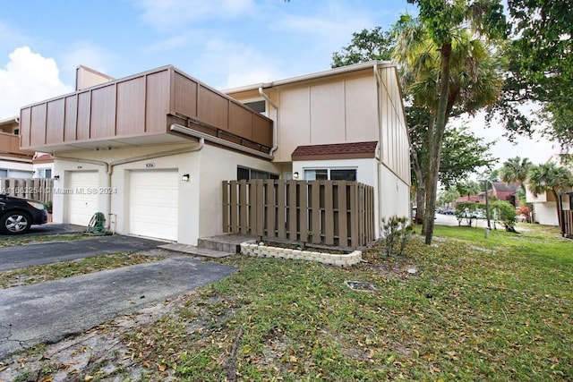 view of front of home featuring a garage, a balcony, and a front lawn