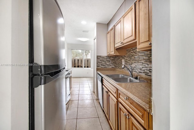 kitchen with light tile patterned floors, stainless steel appliances, sink, and tasteful backsplash