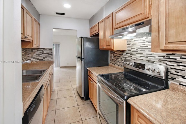 kitchen with appliances with stainless steel finishes, decorative backsplash, light tile patterned floors, sink, and extractor fan