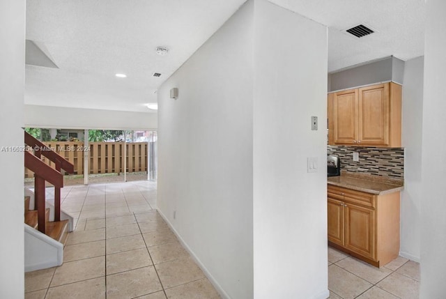 hall featuring light tile patterned flooring