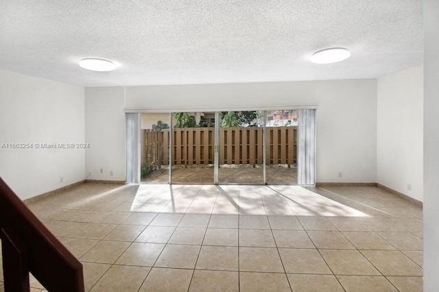 tiled spare room featuring a textured ceiling