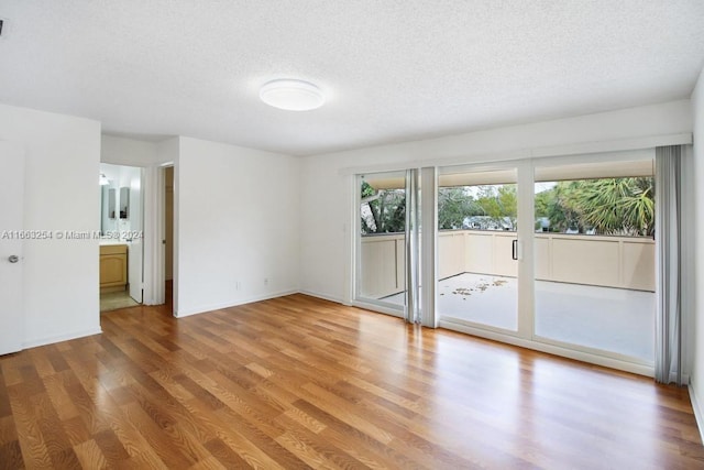 unfurnished room featuring wood-type flooring and a textured ceiling