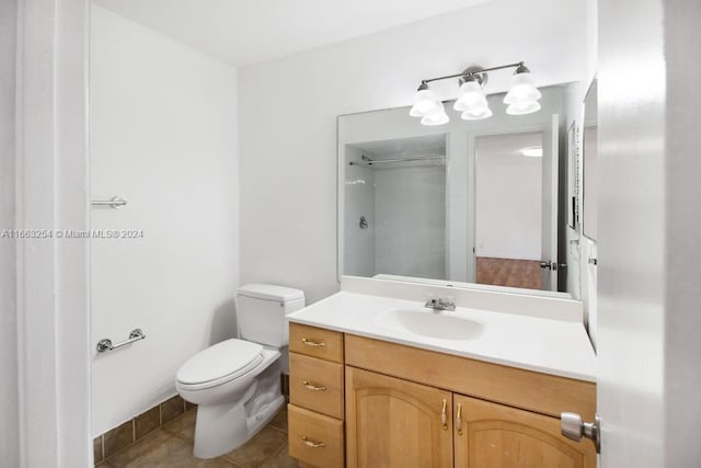 bathroom with tile patterned floors, a shower, vanity, and toilet