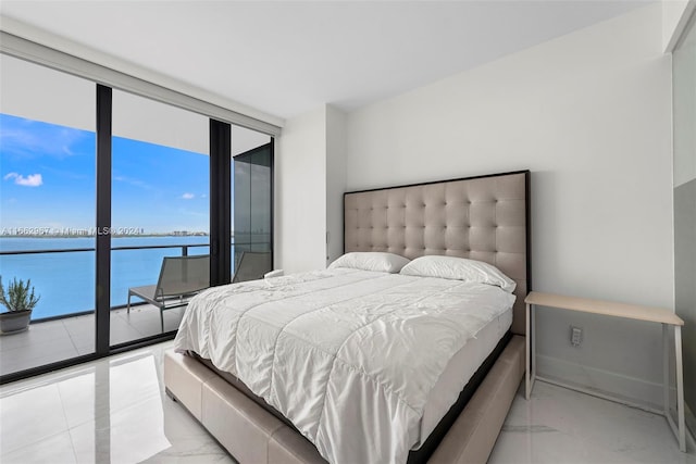 bedroom with access to exterior, multiple windows, and a water view