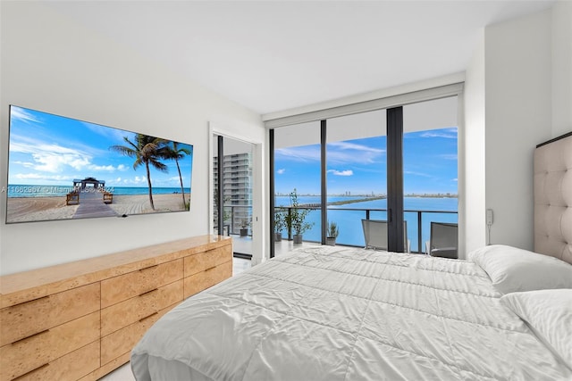 bedroom with access to exterior and a water view