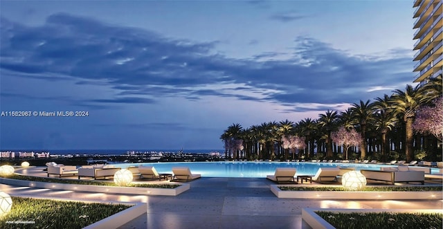 pool at dusk featuring a patio area