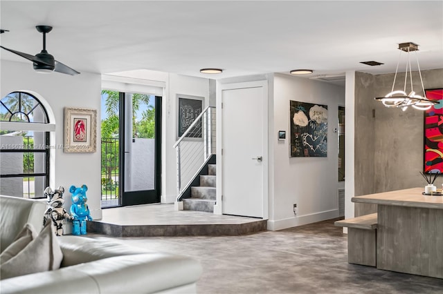 living room featuring ceiling fan with notable chandelier