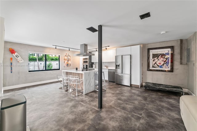 kitchen with white cabinets, island exhaust hood, stainless steel appliances, a center island, and a breakfast bar area