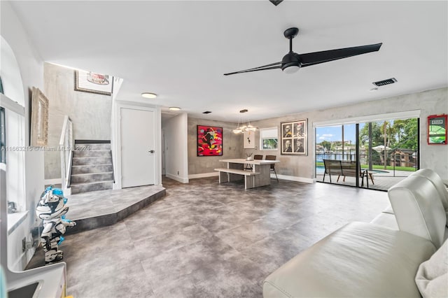 living room featuring ceiling fan with notable chandelier