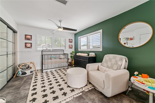 sitting room featuring concrete floors, ceiling fan, and a healthy amount of sunlight