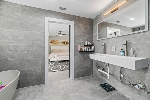 bathroom with tile walls, a washtub, and ceiling fan