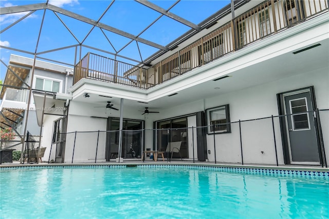 view of swimming pool with glass enclosure and ceiling fan