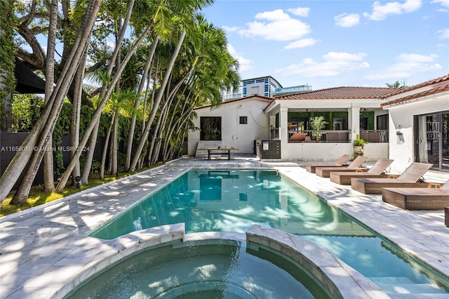 view of swimming pool featuring an in ground hot tub and a patio area