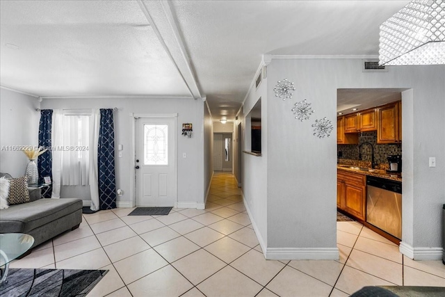 tiled entrance foyer with a textured ceiling, crown molding, and sink