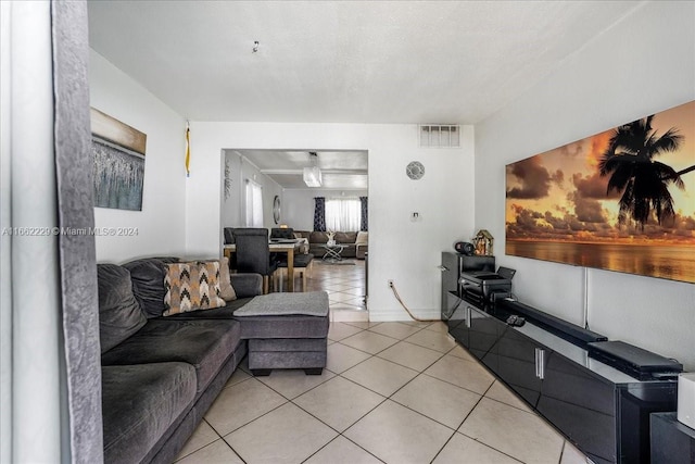 tiled living room featuring a textured ceiling