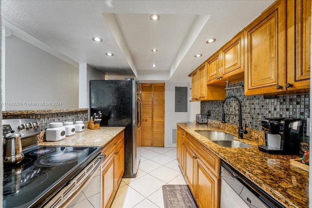 kitchen featuring light stone counters, appliances with stainless steel finishes, sink, and decorative backsplash