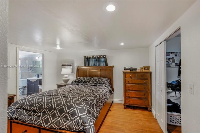 bedroom featuring wood-type flooring, connected bathroom, and a closet