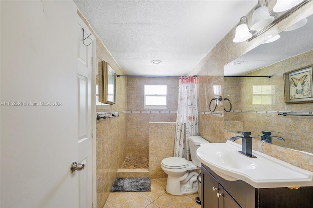 bathroom with tile walls, tile patterned flooring, a shower with curtain, vanity, and toilet