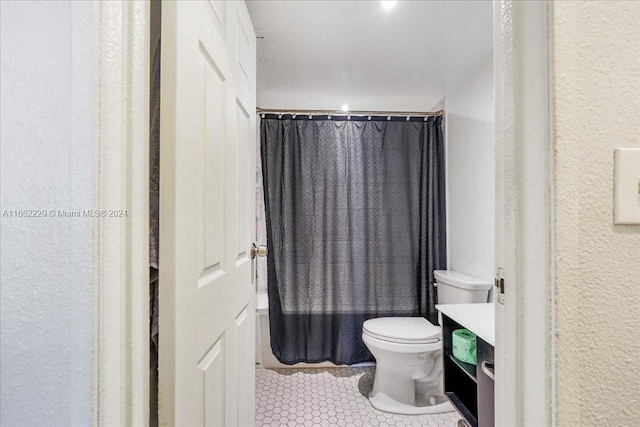 bathroom with vanity, curtained shower, tile patterned floors, and toilet