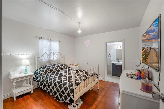 bedroom featuring hardwood / wood-style floors, sink, and ensuite bath