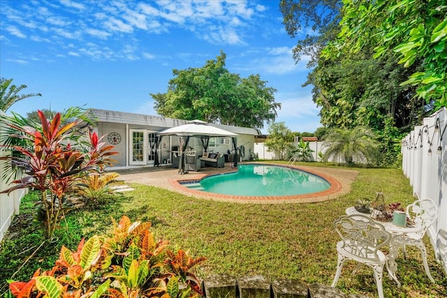 view of swimming pool with a lawn, a gazebo, a patio, and french doors