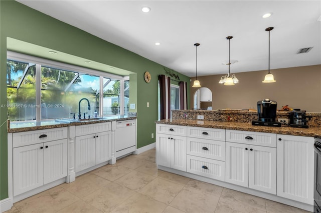 kitchen with pendant lighting, white cabinets, dishwasher, and dark stone countertops