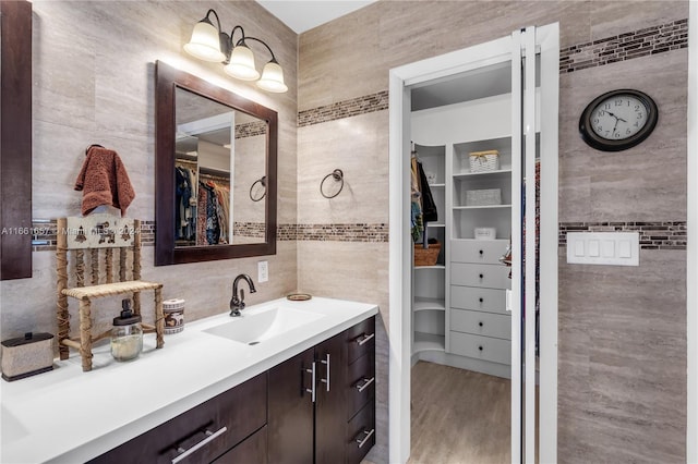 bathroom featuring tile walls, vanity, and hardwood / wood-style floors