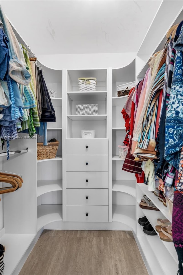 walk in closet with light hardwood / wood-style floors