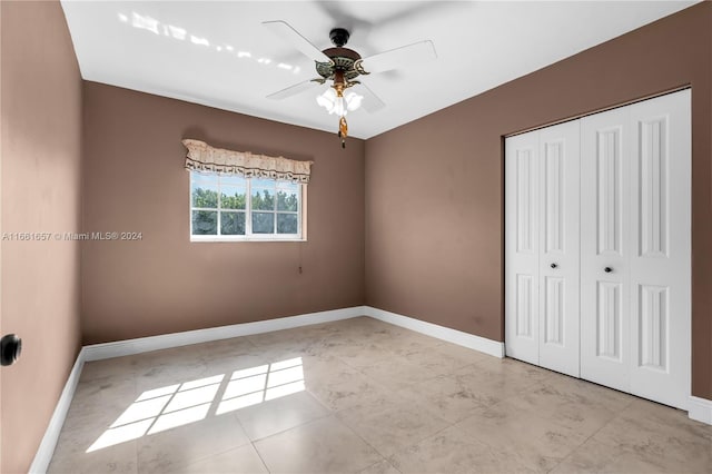 unfurnished bedroom with ceiling fan and a closet