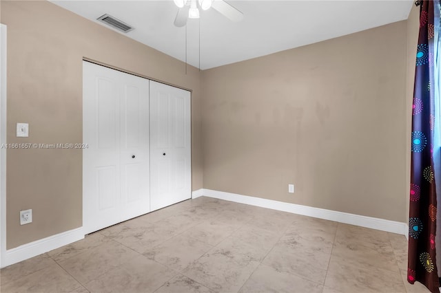 unfurnished bedroom featuring ceiling fan and a closet