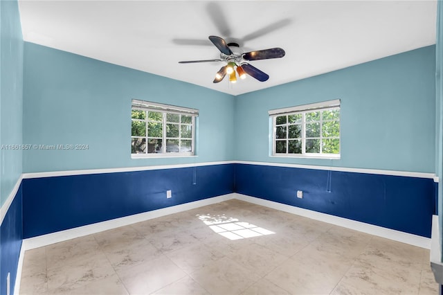 empty room with ceiling fan and a wealth of natural light