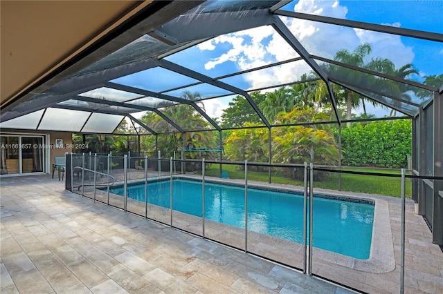 view of pool featuring glass enclosure and a patio