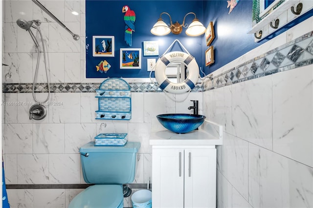 bathroom featuring tile walls, toilet, vanity, and tiled shower