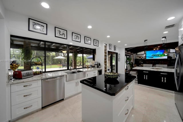 7706 SW 74th Ln, Miami, FL 33143 - kitchen with white cabinetry, a kitchen island, visible vents, stainless steel dishwasher, and a sink