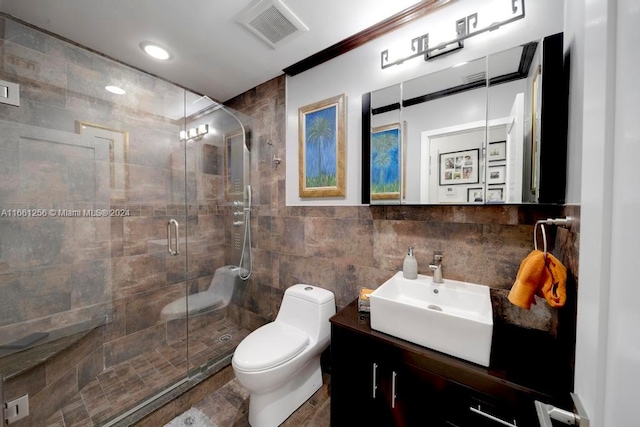 bathroom with tile walls, an enclosed shower, vanity, and toilet