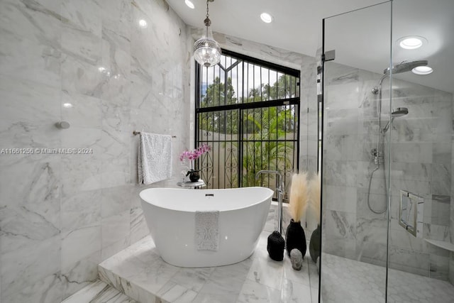 bathroom featuring plus walk in shower and tile walls