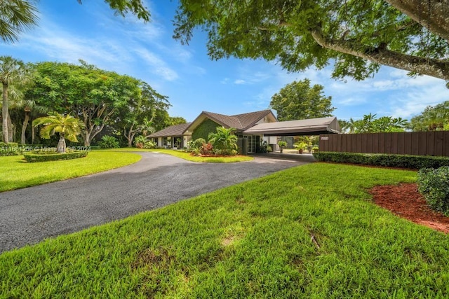 7706 SW 74th Ln, Miami, FL 33143 - view of front of house featuring a front yard, driveway, fence, and a carport