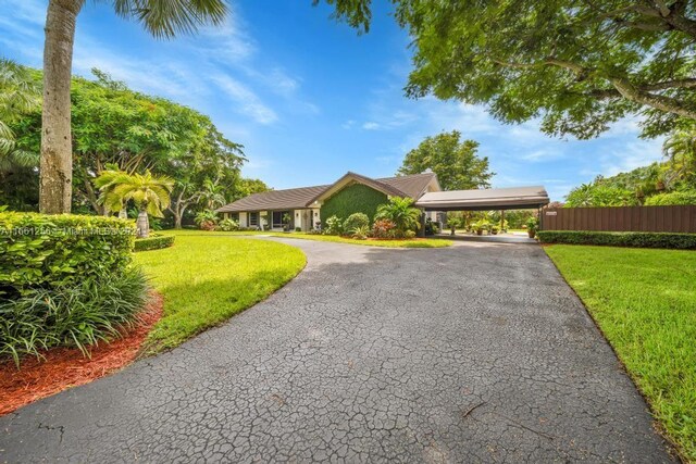 7706 SW 74th Ln, Miami, FL 33143 - view of front of home with a carport, driveway, a front yard, and fence