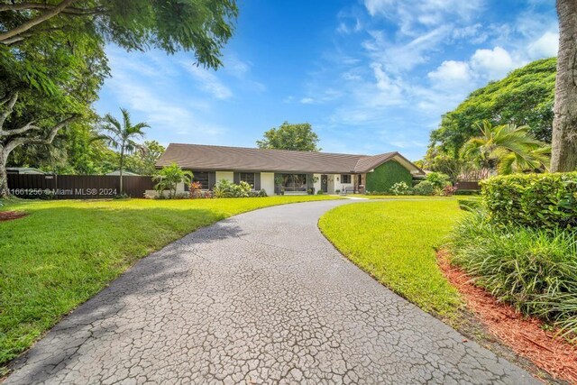 7706 SW 74th Ln, Miami, FL 33143 - single story home featuring driveway, a front yard, and fence