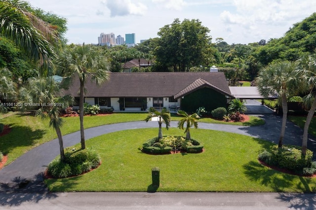 7706 SW 74th Ln, Miami, FL 33143 - view of front of house with a tile roof, a front lawn, curved driveway, and a city view