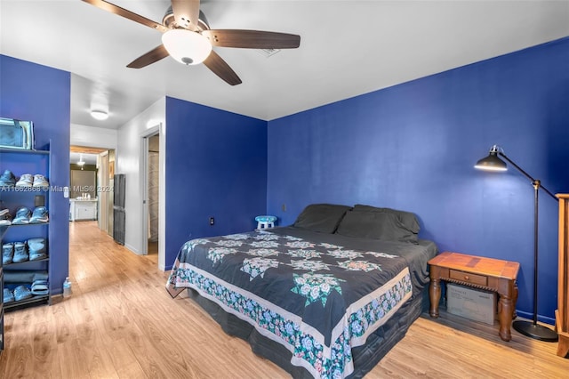 bedroom with light hardwood / wood-style floors, ensuite bath, and ceiling fan