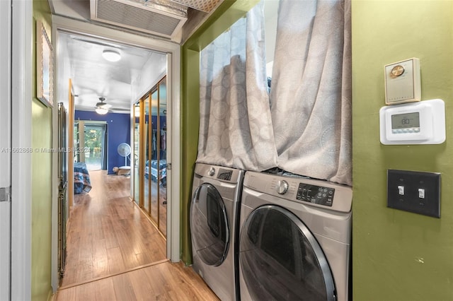 laundry area with ceiling fan, light hardwood / wood-style floors, and washer and clothes dryer