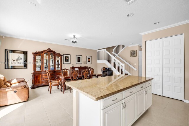 kitchen with dishwasher, crown molding, white cabinetry, and a kitchen island