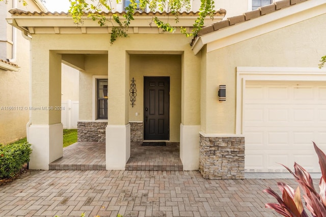 entrance to property featuring a garage and a porch