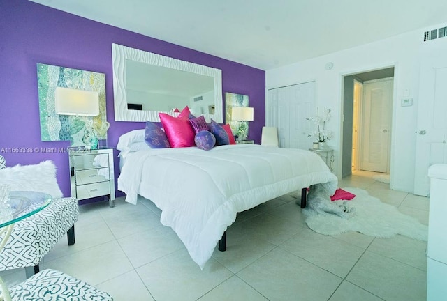 bedroom with light tile patterned floors and a closet