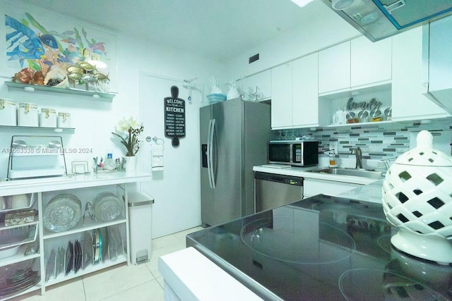 kitchen with decorative backsplash, white cabinetry, light tile patterned floors, stainless steel appliances, and sink