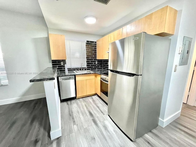 kitchen featuring sink, light brown cabinets, tasteful backsplash, light hardwood / wood-style flooring, and appliances with stainless steel finishes