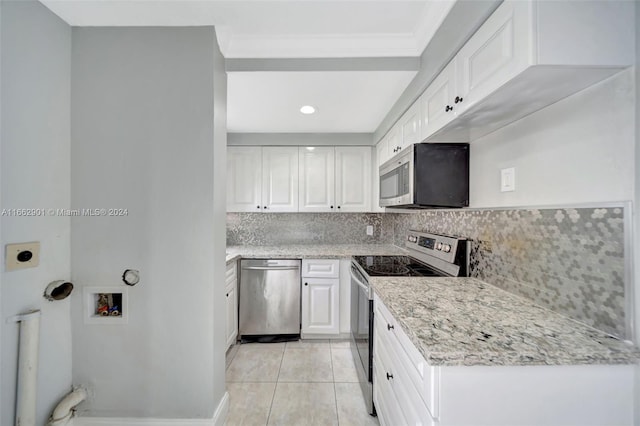 kitchen with stainless steel appliances, white cabinetry, light tile patterned flooring, and backsplash