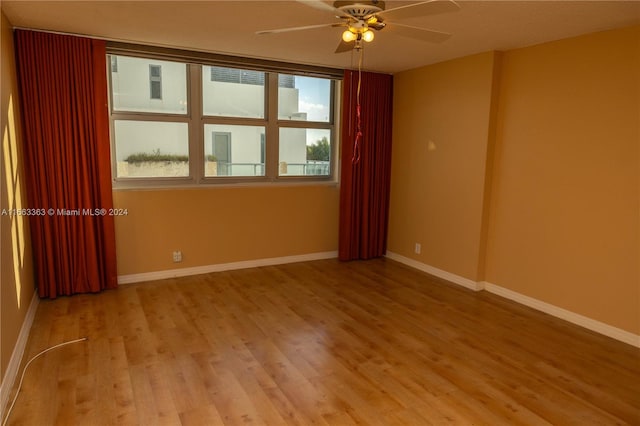 spare room featuring a wealth of natural light, ceiling fan, and light hardwood / wood-style floors